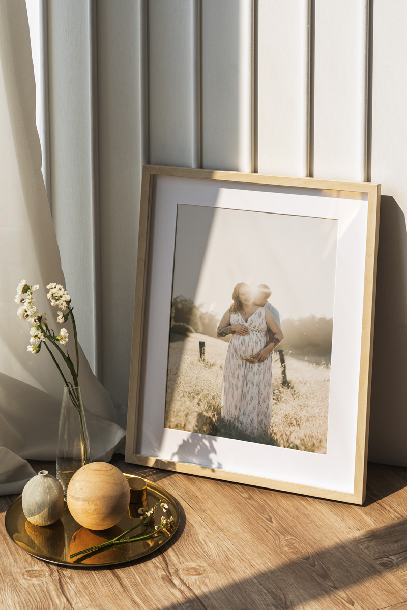 Picture frame mockup by a white wall on the wooden floor