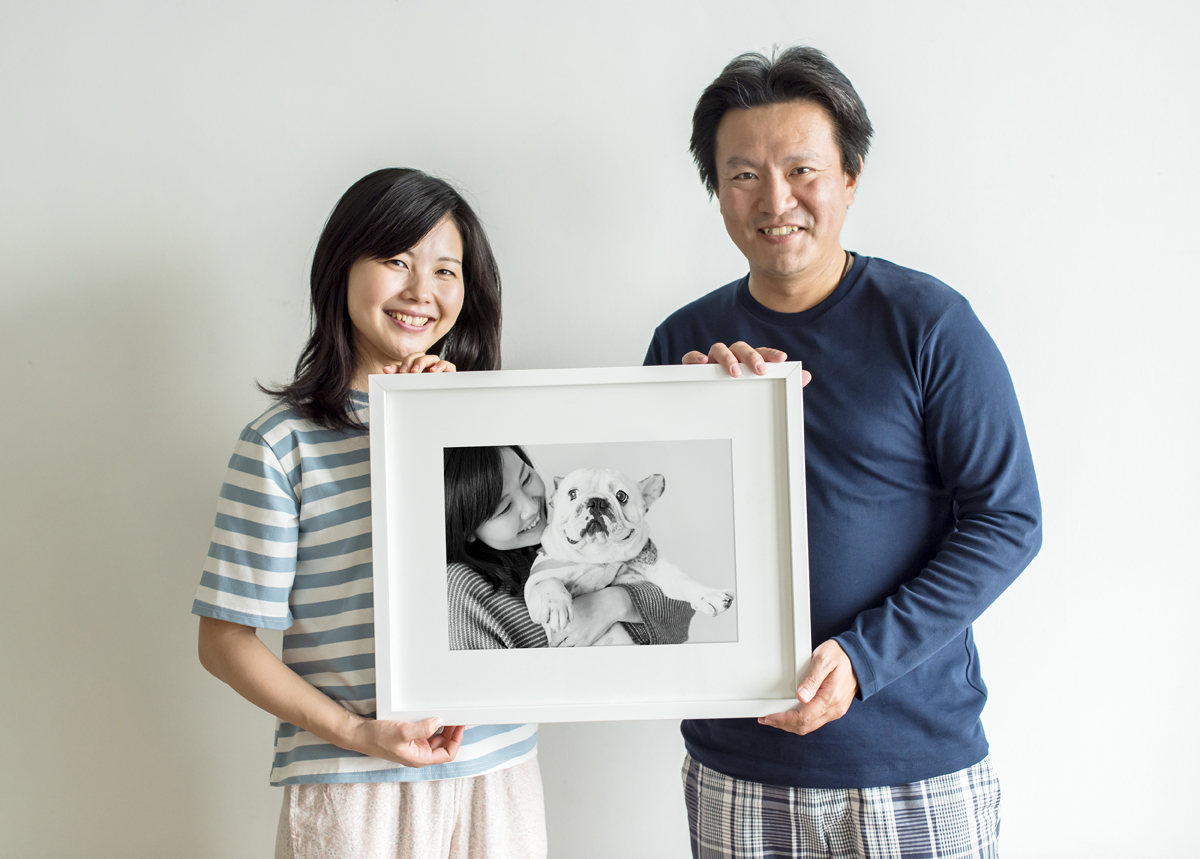 Asian couple holding photo frame together